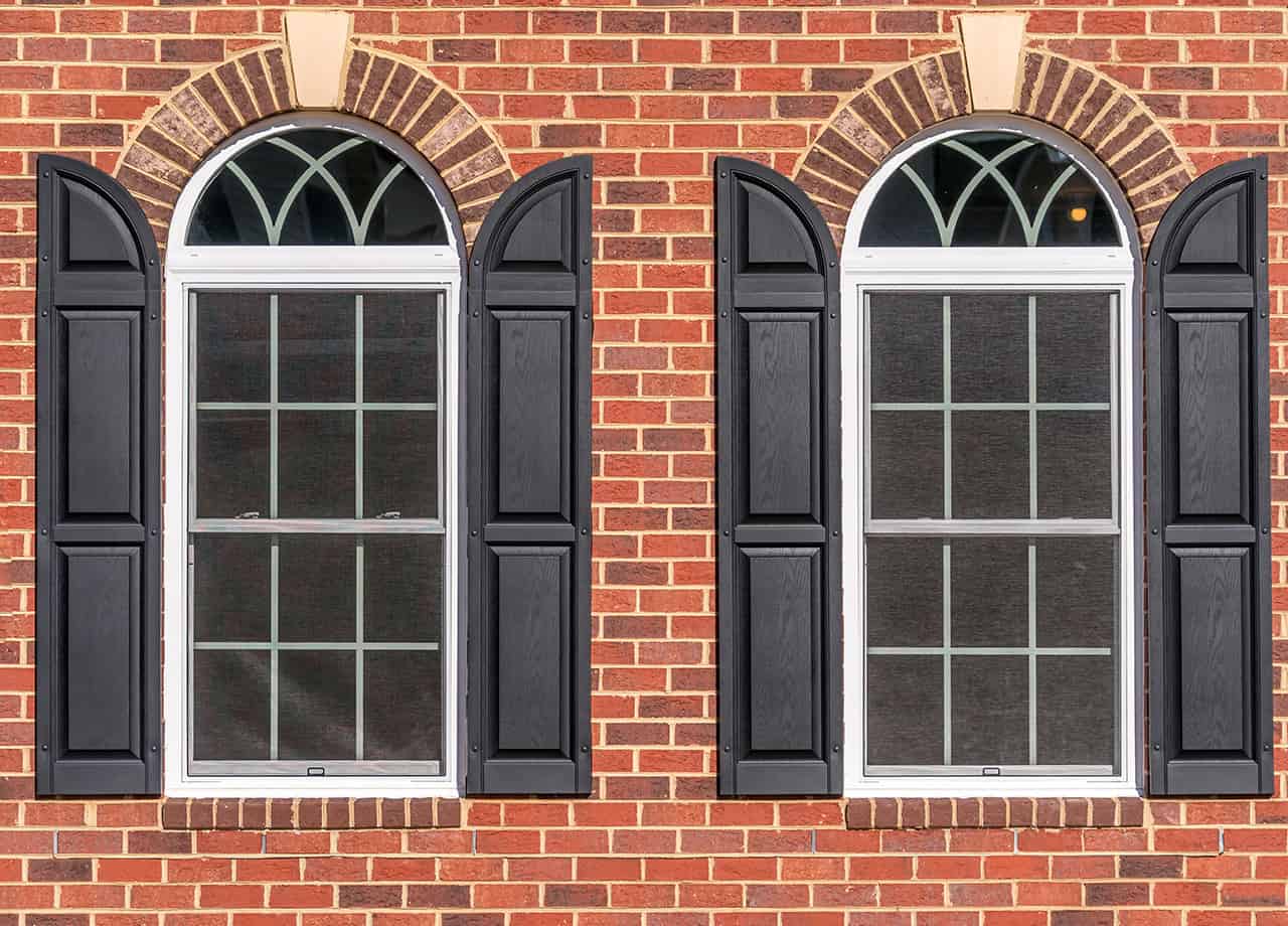 Close up image of brick siding on a house with double pane arched windows. Our skilled siding contractors can install brick siding for your home in the Milford OH & Cincinnati OH areas.